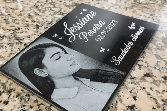 Detalhe de gravação em baixo-relevo em uma placa de granito